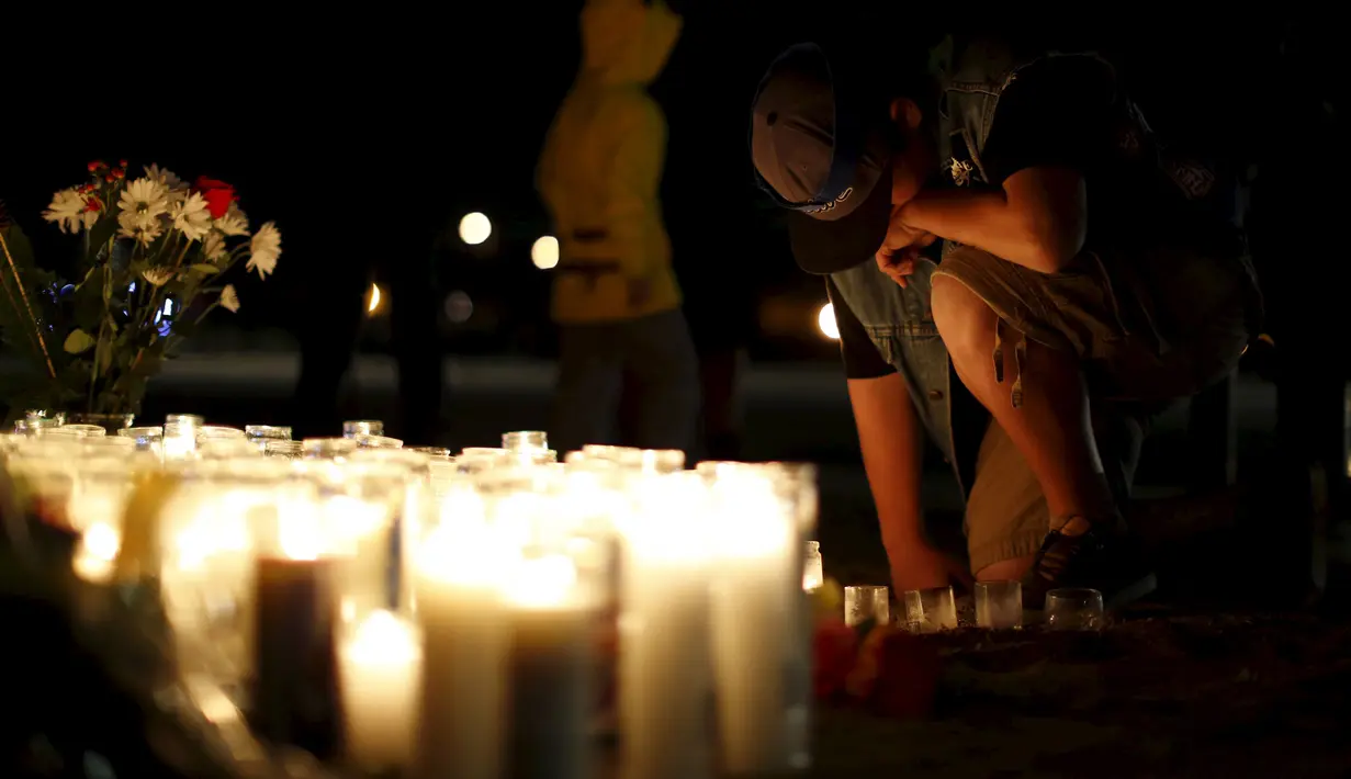 Aidan Solis (11) berlutut saat mengikuti aksi  menyalakan lilin dan berdoa bersama di San Bernardino, California, Jumat (4/12). Aksi tersebut untuk korban penembakan brutal di pusat lembaga pelayanan sosial yang menewaskan 14 orang (REUTERS/Mario Anzuoni)