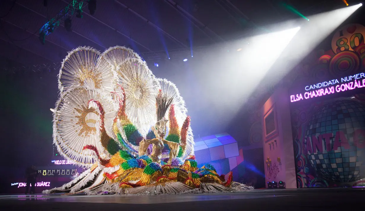 Kontestan untuk nominasi Ratu Karnaval Santa Cruz memamerkan bajunya dalam ajang Karnaval Santa Cruz de Tenerife, Spanyol, Rabu (3/2). Para wanita cantik ini mengenakan gaun dengan tinggi lebih dari 5 meter dan berat mencapai 80 kg. (DESIREE MARTIN/AFP)