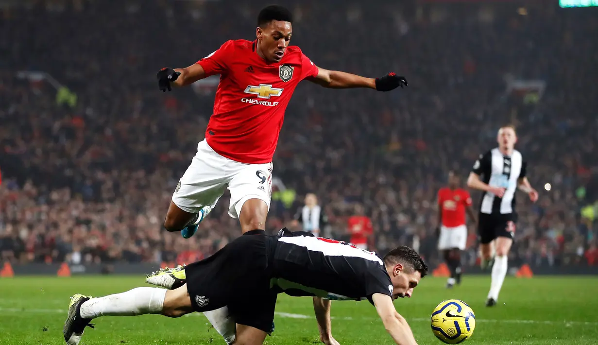 Pemain Manchester United Anthony Martial (kiri) berebut bola dengan pemain Newcastle United Fabian Schar pada pertandingan Liga Inggris di Old Trafford, Manchester, Inggris, Kamis (26/12/2019). Manchester United menang 4-1 atas Newcastle United. (Martin Rickett/PA via AP)