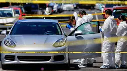 Tim forensik melakukan olah tempat kejadian perkara penembakan pengendara mobil sport Porsche oleh orang tidak dikenal di Guadalajara, Meksiko, (14/3). Pihak berwenang mencatat 25.339 pembunuhan pada tahun 2017. (AFP Photo/Ulises Ruiz)