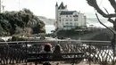 Dua wanita duduk di bangku selama cuaca musim dingin yang hangat di sepanjang garis pantai kota Biarritz di Perancis barat (17/2). Kota ini terletak di region Aquitane, Departemen Pyrénées-Atlantiques. (AFP Photo/Iroz Gaizka)