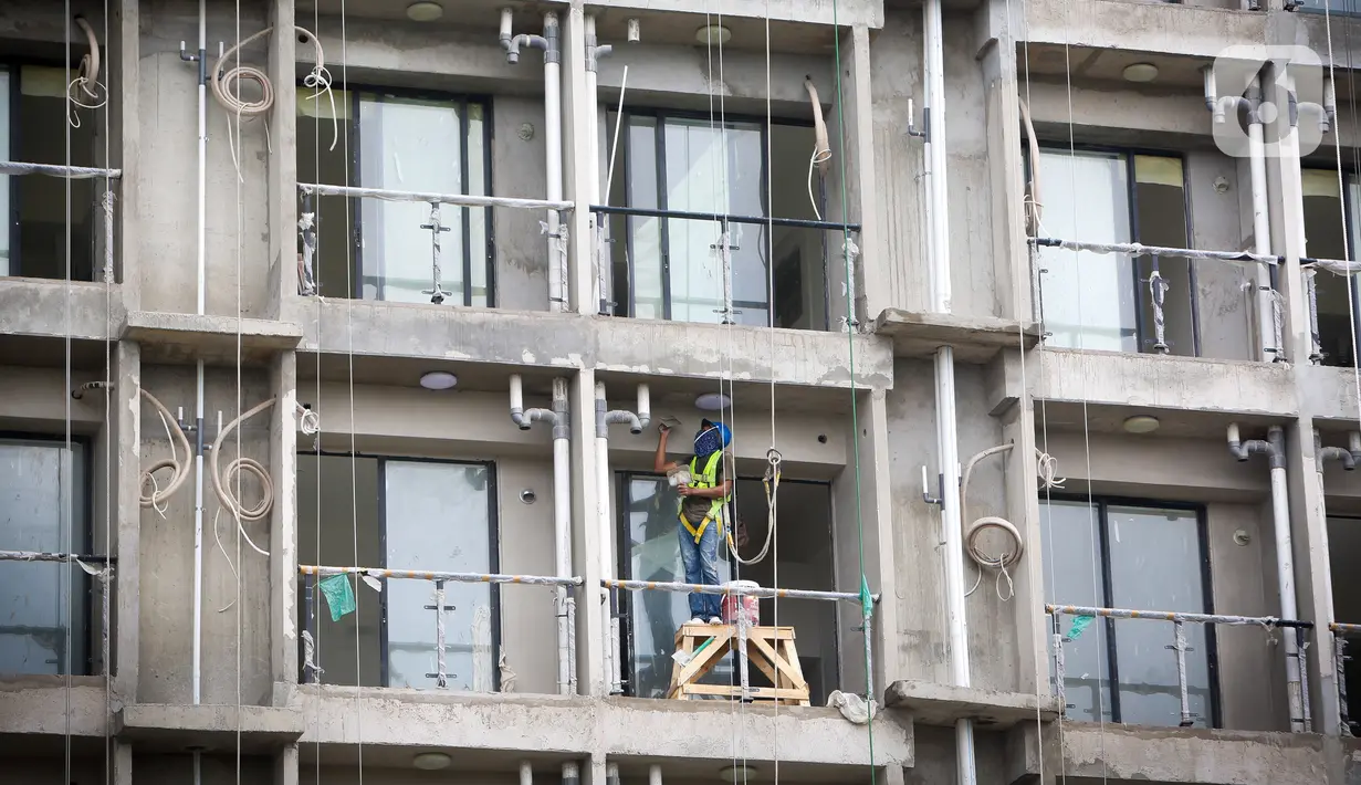Pekerja menyelesaikan proyek pembangunan apartemen di kawasan Tangerang Selatan, Rabu (25/11/2020). Ekspektasi investor untuk berinvestasi di apartemen berkurang disebabkan turunnya harga sewa apartemen dan stagnansi harga jual. (Liputan6.com/Angga Yuniar)