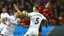 Pemain Liverpool, Roberto Firmino berebut bola dengan bek Swansea City, Mike van der Hoorn dalam lanjutan Premier League di Stadion Liberty, Selasa (23/1). Liverpool tumbang 0-1 dari penghuni dasar klasemen Liga Inggris Swansea. (Geoff CADDICK/AFP)