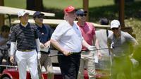 Presiden AS Donald Trump bermain golf dengan PM Jepang Shinzo Abe. Dok: Kyodo/AP