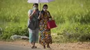 Wanita etnis Khasi dengan pakaian tradisional mengenakan masker berjalan di desa Umwang, di sepanjang perbatasan negara bagian Assam-Meghalaya, India, Rabu (27/10/2021). Lebih dari 60 persen dari 1,3 miliar warga India bertani. (AP Photo/Anupam Nath)