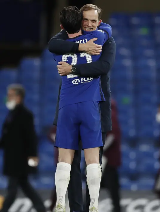 Pelatih Chelsea, Thomas Tuchel tersenyum saat memeluk bek Ben Chilwell usai pertandingan melawan Real Madrid pada leg kedua semifinal Liga Champions di Stamford Bridge di London, Kamis (6/5/2021). Kemenangan ini membuat Tuchel mencetak rekor bersejarah di Liga Champions. (AP Photo/Alastair Grant)