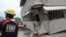 Tim penyelamat memeriksa  bangunan yang runtuh setelah gempa melanda Padada, provinsi Davao del Sur, Filipina selatan (15/12/2019). Gempa tmenyebabkan bangunan tiga lantai runtuh dan membuat warga panik bergegas keluar dari pusat perbelanjaan, rumah dan bangunan lain. (AP Photo)