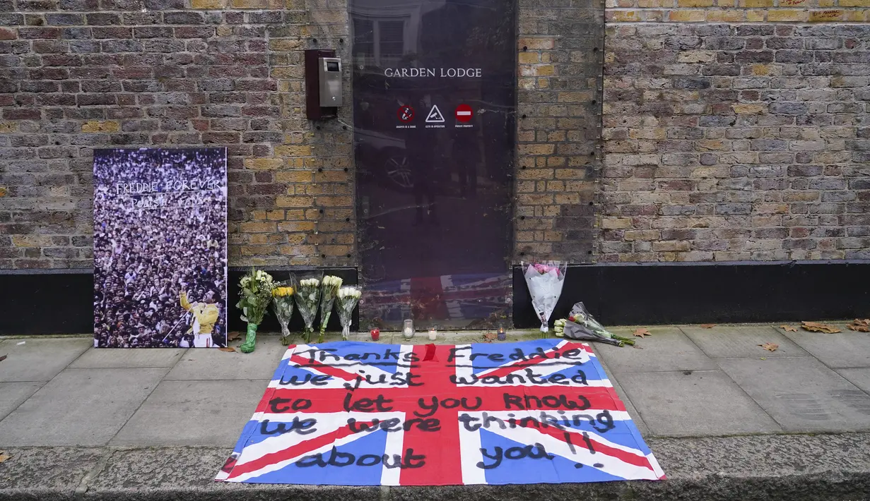Bunga, lilin, gambar dan bendera dengan pesan ditinggalkan di luar rumah mendiang Freddie Mercury, pada peringatan 30 tahun kematiannya, di London, Rabu (24/11/2021). Freddie Mercury, penyanyi yang juga pentolan grup band Queen  meninggal dunia pada 24 November 1991. (AP Photo/Alberto Pezzali)