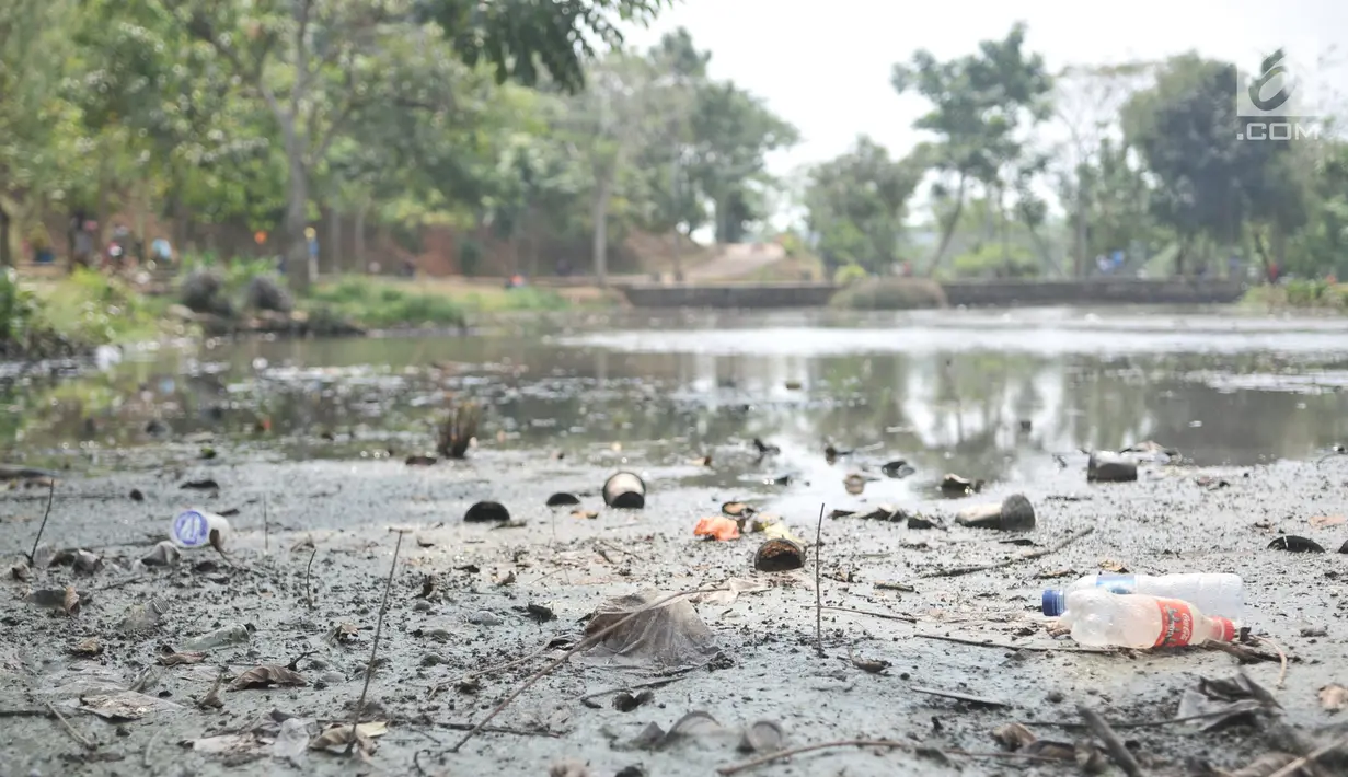 Sampah terlihat di dasar danau yang mengalami kekeringan di Taman Cempaka, Cipayung, Jakarta Timur, Minggu (7/7/2019). Danau buatan ini mengalami kekeringan akibat musim kemarau yang melanda sejak beberapa bulan terakhir. (merdeka.com/Iqbal S Nugroho)