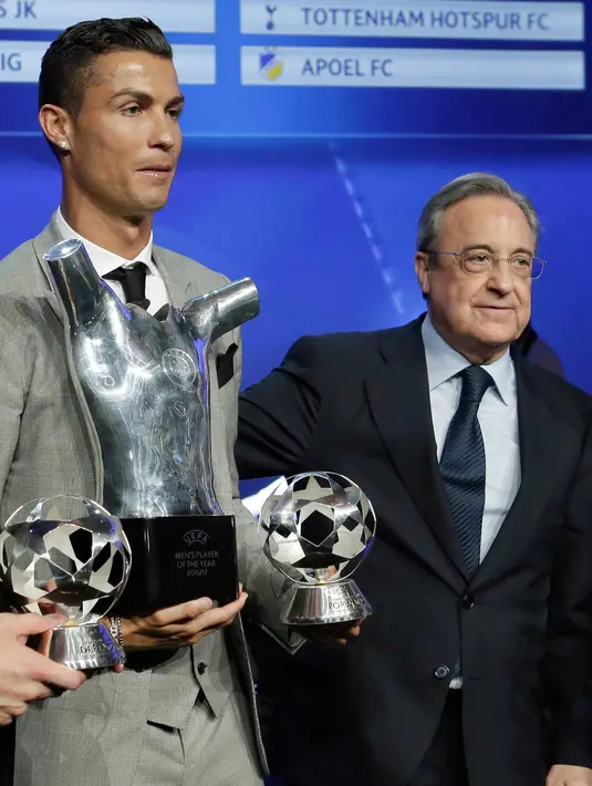 Cristiano Ronaldo memegang piala Penyerang Terbaik Liga Champions dan Pemain Terbaik UEFA 2016/17 berfoto bersama presiden Real Madrid Florentino Perez di Grimaldi Forum, Monaco (24/8). (AP Photo/Claude Paris)