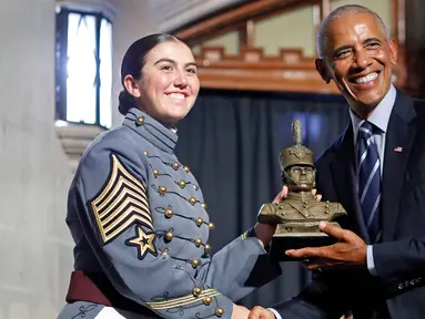 Mantan Presiden Amerika Serikat (AS), Barack Obama (kanan) menerima patung kadet dalam upacara penganugerahan Sylvanus Thayer Award 2024 dari Akademi Militer AS di West Point, New York, pada 19 September 2024. (KENA BETANCUR/AFP)