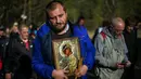 Seorang pria membawa simbol Perawan Maria selama prosesi keagamaan tahunan di Biara Bachkovo, Bulgaria (9/4). Prosesi keagamaan yang diadakan tiap tahun ini dilaksanakan pada hari kedua Paskah Ortodoks. (AFP Photo/Nikolay Doychinov)