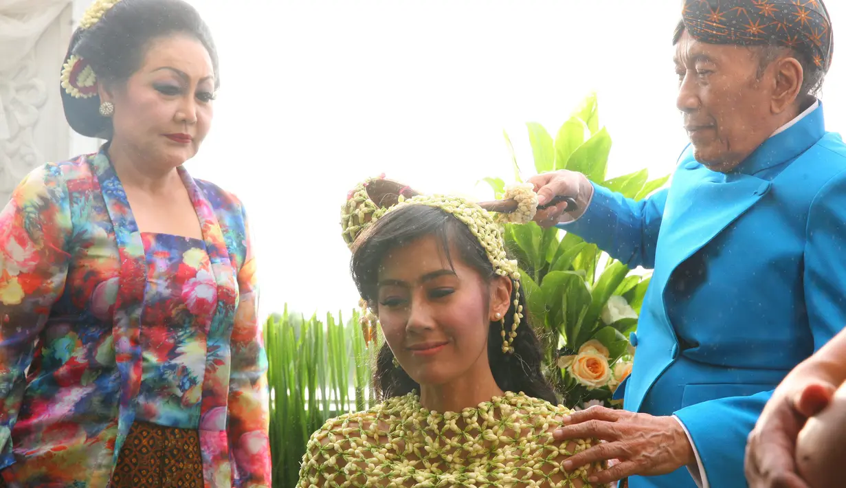 Setelah sampai di tempat yang tidak jauh dari acara pengajian, Rasti mulai siraman. Ayah bintang film Di Sini Ada Setan itu duduk di apit oleh kedua orang tuanya.  (Nurwahyunan/Bintang.com)