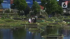 Warga berdoa saat ziarah kubur pada hari kedua Idul Fitri 1441 Hijriah di Tempat Pemakaman Umum (TPU) Semper, Jakarta, Senin (25/5/2020). Di tengah pandemi Covid-19,  peziarah kubur di TPU Semper berkurang. (merdeka.com/Imam Buhori)