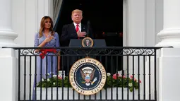 Presiden Donald Trump dan Ibu Negara AS, Melania saat menyanyikan lagu kebangsaan pada acara piknik merayakan Hari Kemerdekaan di halaman Gedung Putih, Rabu (4/7). Trump menggelar acara piknik untuk menjamu keluarga-keluarga militer. (AP/Alex Brandon)