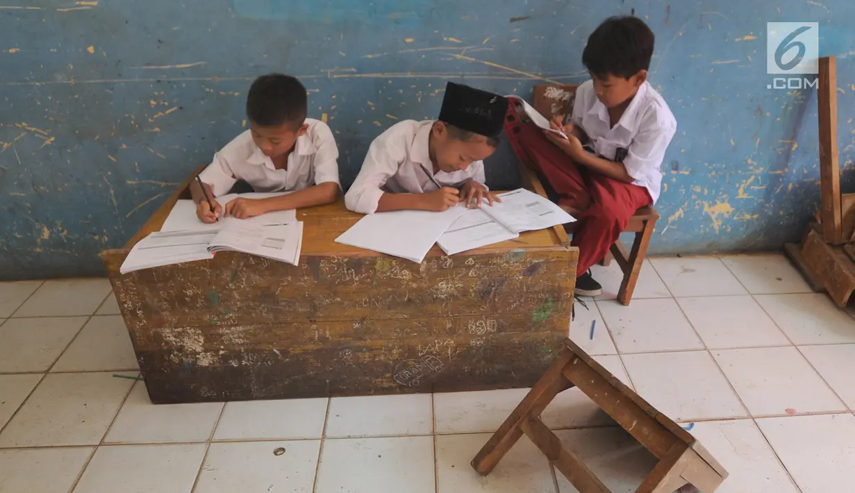 Murid-murid kelas V melakukan kegiatan belajar pada meja yang diubah menjadi kursi dan tempat belajar di SDN Kertajaya 2, Rumpin, Bogor (22/7/2019). Sekolah dengan jumlah 280 murid  dan hanya berjarak sekitar 50 km dari ibukota ini tidak dilengkapi WC dan perpustakaan. (merdeka.com/Arie Basuki)