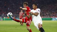 Pemain Bayern Munchen, Thomas Muller, berduel dengan striker Sevilla, Luis Muriel pada laga leg kedua perempat final Liga Champions di Allianz Arena, Kamis (12/4/2018) dini hari WIB. (AP Photo/Matthias Schrader)