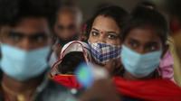 Penumpang yang mengenakan masker menunggu pemeriksaan tes COVID-19 di stasiun kereta jarak jauh di Mumbai, Maharashtra, Minggu (21/3/2021). India sedang menghadapi gelombang baru infeksi Covid-19 dan mencatat rekor lonjakan harian tertinggi dalam hampir empat bulan terakhir. (AP Photo/Rafiq Maqbool)
