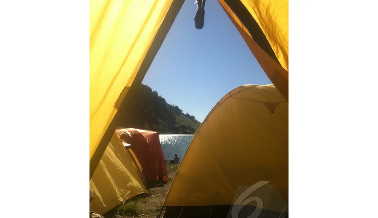 Dari dalam sebuah tenda, kilauan air Ranu Kumbolo di pagi hari seolah mengajak para pendaki untuk merasakan kesejukannya (Liputan6.com/Andi Jatmiko).