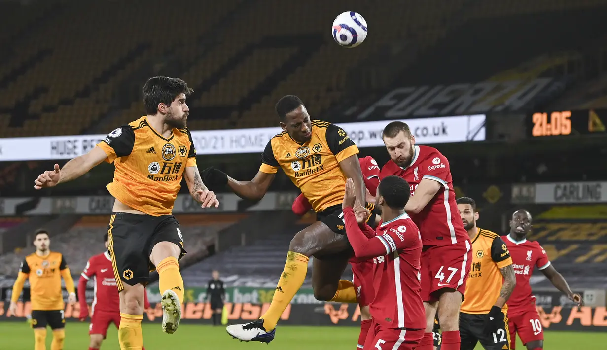 Bek Wolverhampton Wanderers, Willy Boly (tengah) melompat menyundul bola di depan para pemain Liverpool dalam laga lanjutan Liga Inggris 2020/2021 pekan ke-28 di Molineux Stadium, Senin (15/3/2021). Wolverhampton kalah 0-1 dari Liverpool. (AP/Paul Ellis/Pool)