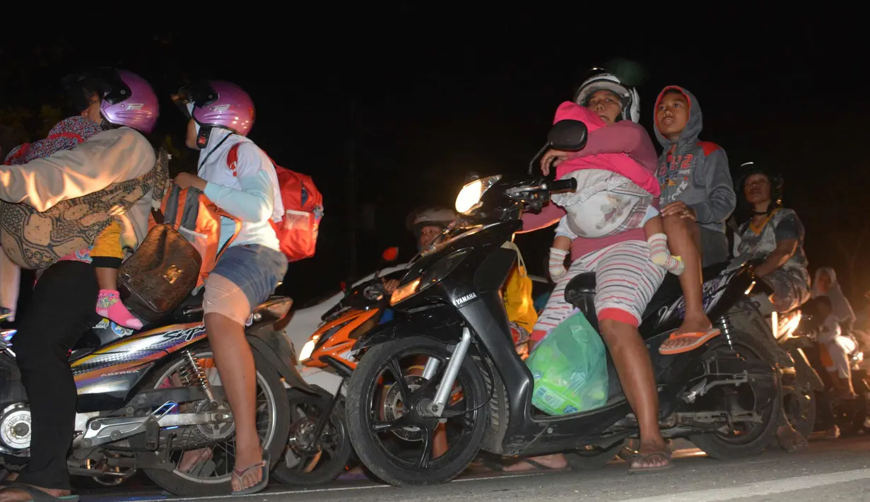 Sejumlah warga mengendarai motor mengungsi ke tempat yang lebih tinggi menyusul terjadinya gempa di Cilacap, Jawa Tengah (16/12). Gempa kuat yang mengguncang Pulau Jawa memicu peringatan akan terjadinya tsunami. (AP Photo / Wagino)