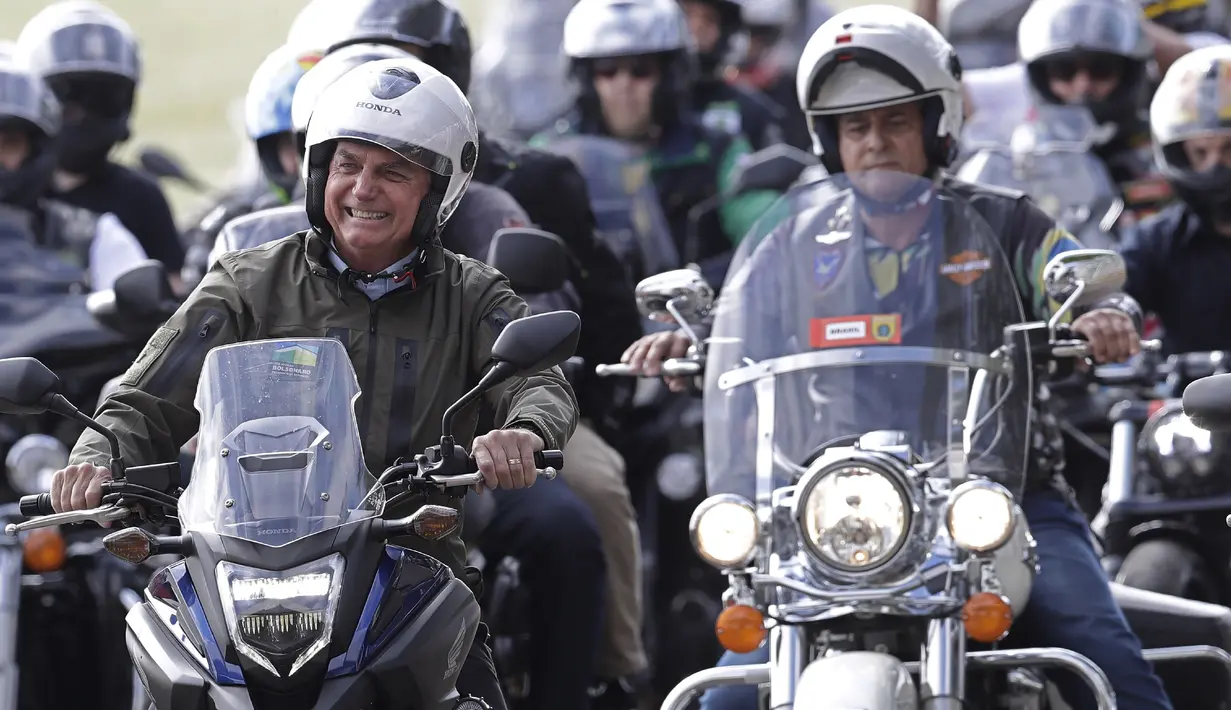 Presiden Brasil Jair Bolsonaro (kiri) melakukan tur sepeda motor dengan para pendukung di Brasilia, di tengah pandemi virus corona pada Minggu (9/5/2021). Bolsonaro memimpin ratusan pengendara motor melakukan perjalanan mengelilingi ibu kota Brasil untuk memperingati Hari Ibu (AP Photo/Eraldo Peres)
