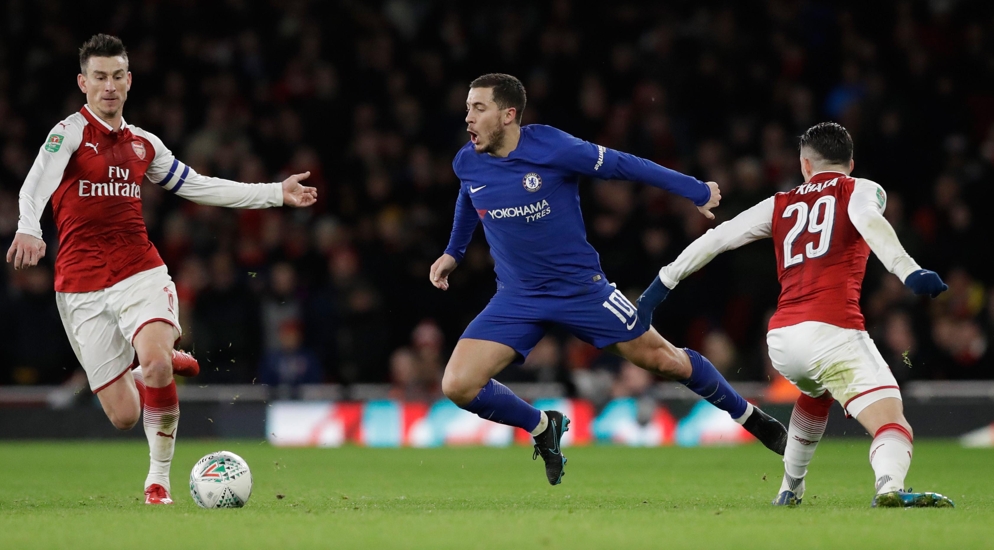 Pemain Chelsea, Eden Hazard berebut bola dengan pemain Arsenal, Granit Xhaka pada laga leg kedua babak semifinal Piala Liga di Stadion Emirates, Kamis (25/1). Arsenal lolos ke final Piala Liga setelah mengatasi perlawanan Chelsea 2-1. (AP/Matt Dunham)