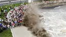 Wisatawan berlari dari gelombang saat mereka menonton gelombang pasang yang tinggi di Hangzhou, Tiongkok, 19 September 2016. (REUTERS)