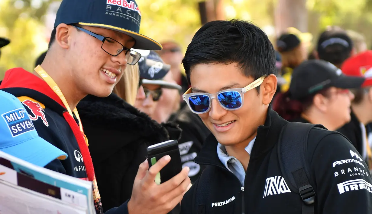 Pembalap Manor Racing, Rio Haryanto berbincang dengan penggemarnya jelang debut pada ajang Formula 1 di GP Australia, Melbourne, Minggu (20/3). Akibat mendapat penalti, Rio Haryanto harus memulai Grand Prix Australia dari posisi buncit. (Paul Crock/AFP)