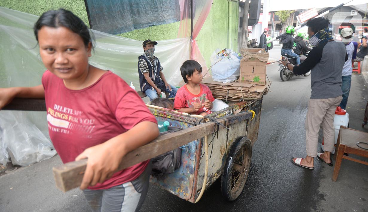 Sejumlah pemuda menyemprotkan cairan disinfektan kepada orang yang akan memasuki RW 10 di kawasan Tanah Kusir, Kelurahan Kebayoran Lama Selatan, Jakarta, Rabu (8/4/2020). Warga menerapkan akses satu pintu masuk pemukiman tersebut untuk mencegah penyebaran corona COVID-19. (merdeka.com/Dwi Narwoko)