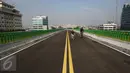Seorang anak ditemani orang tuanya bersepeda di sepanjang jalan layang (elevated) Transjakarta rute Cileduk-Tendean di Jakarta, Minggu (26/2). Belum beroperasinya jalan layang tersebut dimanfaatkan warga untuk berolahraga. (Liputan6.com/Immanuel Antonius)