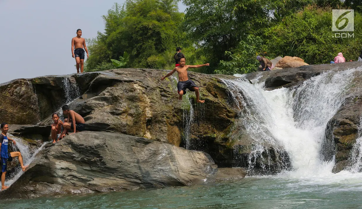 Seorang anak melompat di aliran sungai Gunung Sari, Desa Tajur, Pasirmukti, Citeureup, Bogor, Jawa Barat (24/6/2019). Wisata gratis ini adalah salah satu wahana rekreasi baru warga disekitaran Cibinong dan Citeureup sambil membawa anak anaknya main dan mandi disungai. (Kapanlagi.com/Budy Santoso)