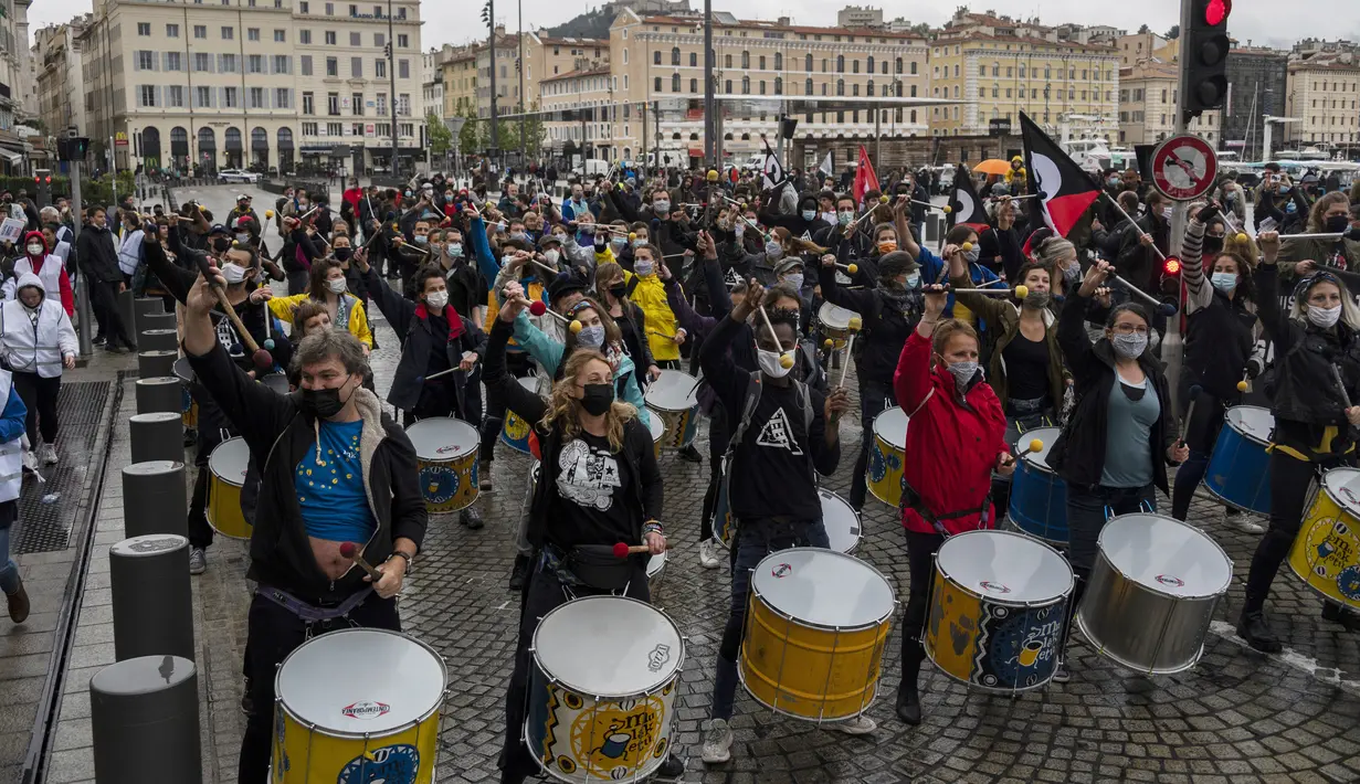 Sebuah drum band batucada tampil selama unjuk rasa tahunan May Day atau Hari Buruh Internasional  di Pelabuhan Vieux di Marseille, Prancis, pada Sabtu (1/5/2021). Dalam rangka memperingati hari buruh tersebut, biasanya para buruh turun ke jalan menyuarakan aspirasinya. (Christophe SIMON / AFP)