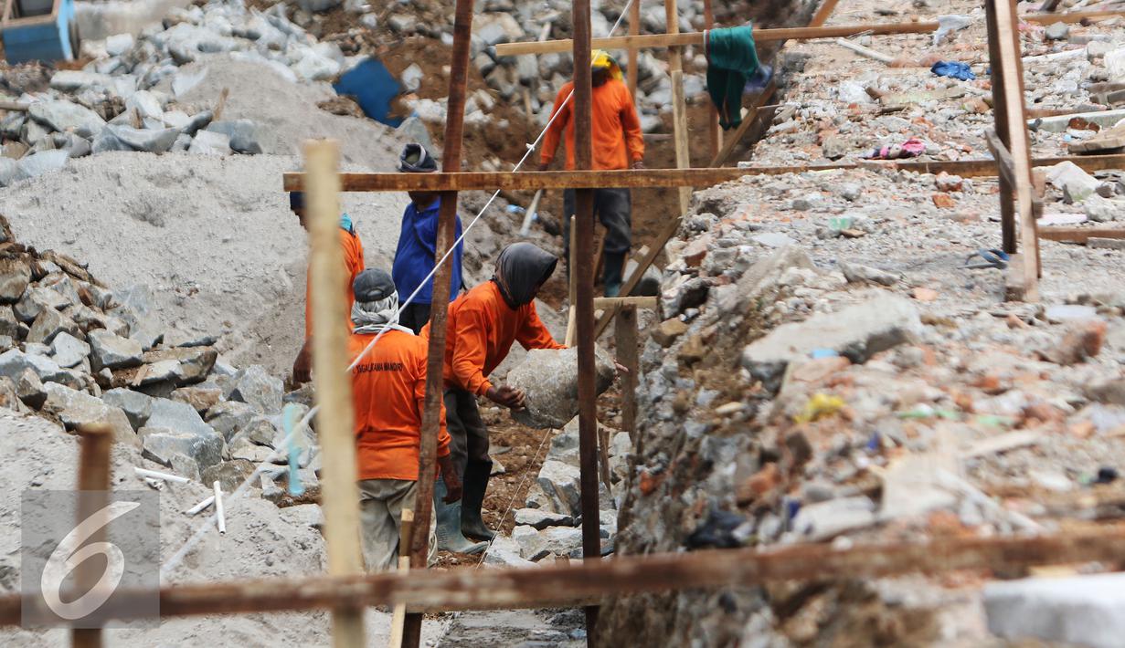 Pekerja memasang batu membuat pondasi turap jalan dalam pengerjaan proyek penataan ulang Kalijodo, Jakarta (18/3). Pengerjaan di sepanjang Jalan Kepanduan II, mulai dari ujung di Jalan Teluk Gong, hingga Jalan Tubagus Angke. (Liputan6.com/Gempur M Surya)