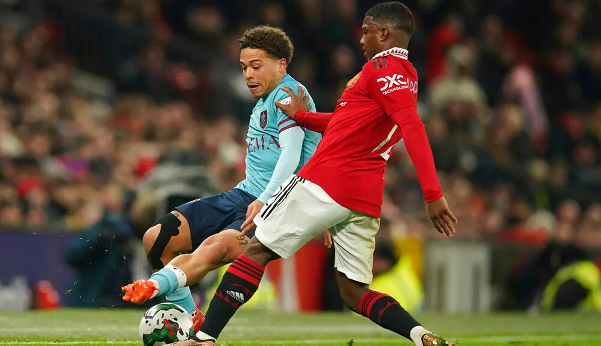 Pemain Manchester United Tyrell Malacia menantang pemain Burnley Manuel Benson pada pertandingan sepak bola putaran keempat Piala Liga Inggris di Old Trafford, Manchester, Inggris, 21 Desember 2022. (AP Photo/Dave Thompson)