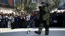 Seorang anggota tim penjinak bom membawa benda mencurigakan yang menghebohkan warga di kompleks kantor Singha Durbar, Kathmandu , Nepal, (1/3). Warga sekitar mendadak heboh karena mengira benda tersebut adalah sebuah bom. (REUTERS / Navesh Chitrakar)