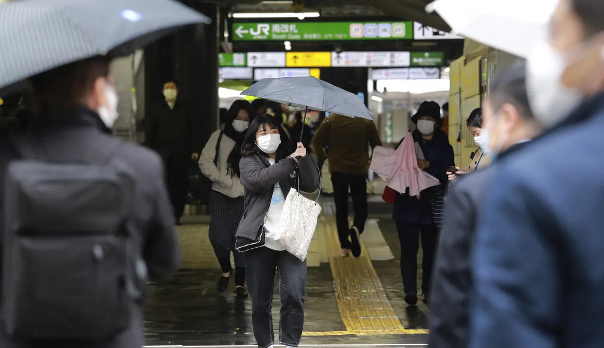 Warga memakai masker untuk melindungi dari penyebaran virus corona berdiri di stasiun kereta di Tokyo (8/3/2021). Pemerintah Jepang memperpanjang keadaan darurat di wilayah Tokyo hingga 21 Maret karena sistem medis masih disaring oleh pasien COVID-19. (AP Photo/Koji Sasahara)