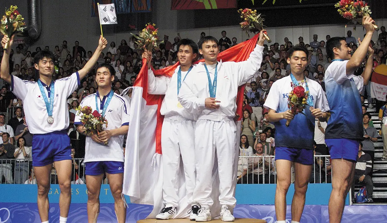 Pada Olimpiade Sydney tahun 2000, pasangan ganda putra, Tony Gunawan dan Chandra Wijaya (tengah) berhasil bawa medali emas untuk Indonesia. Mereka berhasil kandaskan Lee Dong Soo dan Yoo Yong Sung (kiri) pasangan dari Korea Selatan. (Foto: AFP/Robyn Beck)