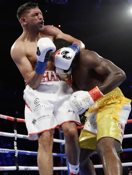 Reaksi Amir Khan (kiri) saat mendapat pukulan rendah dari Terence Crawford pada perebutan gelar juara dunia tinju kelas welter WBO di Madion Square Garden, New York, Amerika Serikat, Minggu (21/4). Pukulan rendah Crawford pada ronde enam membuat Khan mengerang kesakitan. (AP Photo/Frank Franklin II)