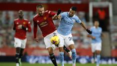 Bek Manchester United, Luke Shaw (kiri), berebut bola dengan striker Manchester City, Riyad Mahrez, dalam laga lanjutan Liga Inggris 2020/21 pekan ke-12 di Old Trafford Stadium, Sabtu (12/12/2020). Manchester United bermain imbang 0-0 dengan Manchester City. (AFP/Phil Noble/Pool)