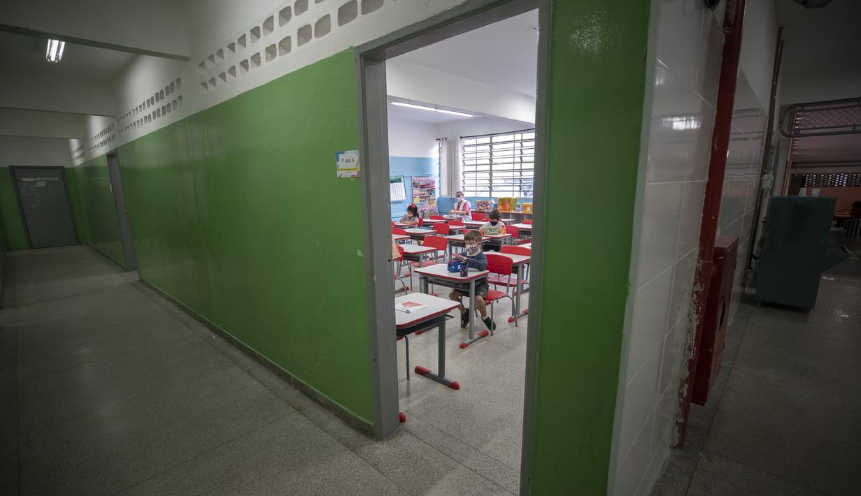 Sejumlah siswa mengenakan masker pada hari pertama kembali ke kelas tatap muka di tengah pandemi COVID-19 di sekolah umum Raul Antonio Fragoso di Sao Paulo, Brasil (8/2/2021). Sekolah tatap muka diizinkan dengan maksimal 35% siswanya. (AP Photo/Andre Penner)