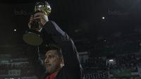 Pelatih Persebaya, Alfredo Vera, mengangkat piala merayakan gelar juara Liga 2 usai mengalahkan PSMS pada laga final di Stadion GBLA, Bandung, Selasa (28/11/2017). Persebaya menang 3-2 atas PSMS. (Bola.com/Vitalis Yogi Trisna)
