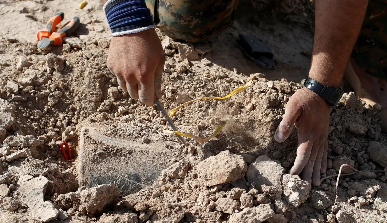 Anggota YBS yang berafiliasi dengan Partai Pekerja Kurdistan (PKK) menemukan ranjau  di sebuah jalur yang biasa dilintasi ISIS, Irak utara, 30 April 2016. Mereka mencari ranjau yang ditanam ISIS dan kemudian memindahkannya. (REUTERS/Goran Tomasevic)