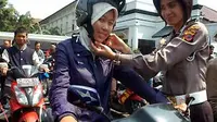 Petugas kepolisian mengenakan helm standar SNI kepada pengendara motor di Polrestabes Bandung dalam acara &quot;Kampanye Keselamatan Lalulintas&quot;, Bandung, Jawa Barat, Sabtu (20/11). (Antara)