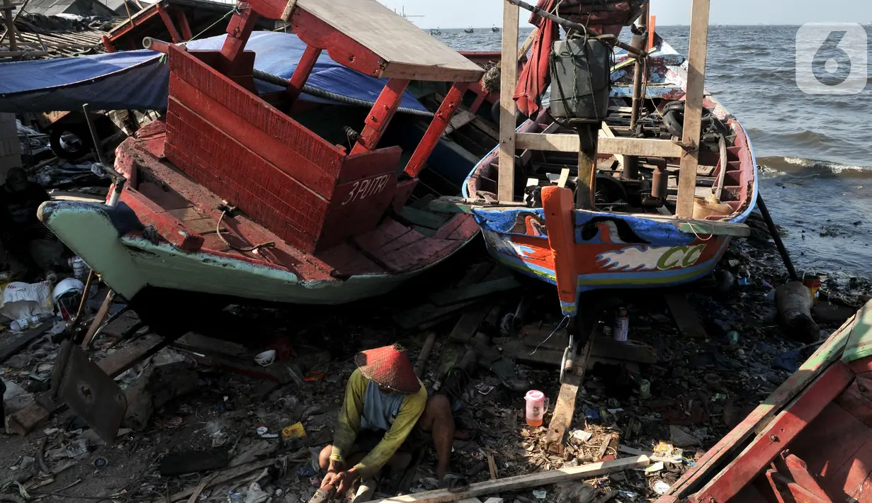Pekerja menyelesaikan proses perbaikan kapal nelayan di pesisir Marunda, Jakarta, Selasa (22/10/2019). Untuk jasa perbaikan satu buah kapal biasanya dipatok dengan harga Rp 15 juta dalam waktu pengerjaan hingga sebulan. (merdeka.com/Iqbal Nugroho)