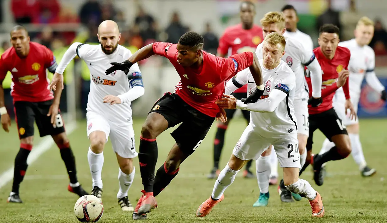 Gelandang Manchester United, Paul Pogba, berusaha melewati hadangan pemain FC Zorya Luhansk. Meski bermain tandang, Setan Merah lebih menguasai jalnnya laga dengan penguasaan bola 69 persen. (AFP/Sergei Supinsky)