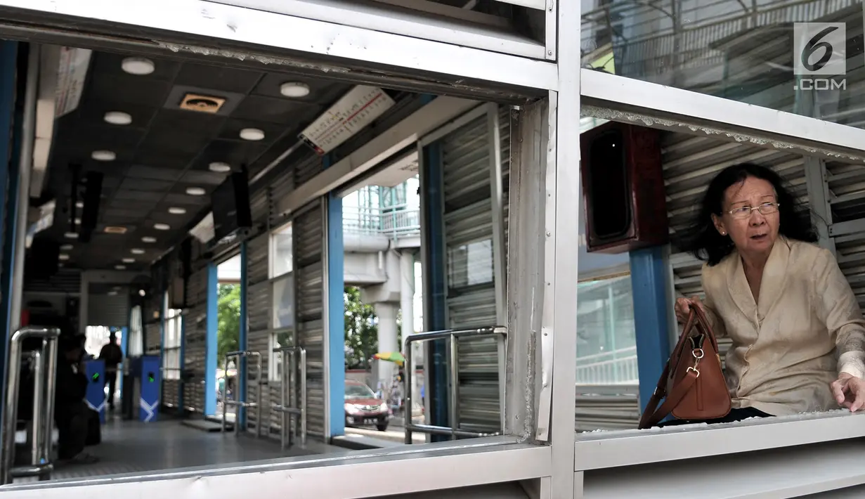 Penumpang menunggu bus di Halte Transjakarta Pasar Rumput, Manggarai, Jakarta, Minggu (3/2). Tawuran antarwarga menyebabkan Halte Transjakarta Pasar Rumput rusak akibat terkena lemparan batu. (Merdeka.com/Iqbal Nugroho)