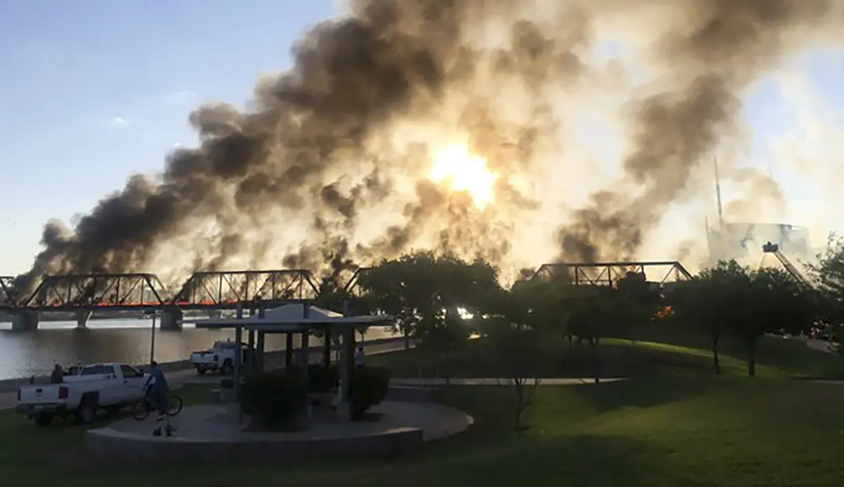 Asap membumbung saat kereta barang tergelincir dan terbakar di jembatan Danau Kota Tempe, Arizona, Amerika Serikat, Rabu (29/7/2020). Kecelakaan terjadi sekitar pukul 06.15 waktu setempat. (Daniel Coronado via AP)