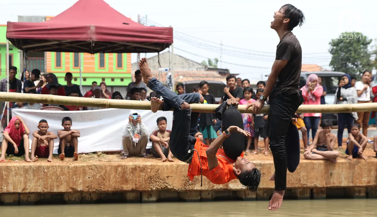 Anak-anak bermain lomba pukul bantal di sekitar Kalimalang, Jakarta, Sabtu (17/8/2019). Beragam lomba permainan digelar warga untuk menyemarakkan HUT ke-74 Republik Indonesia. (Liputan6.com/Helmi Fithriansyah)