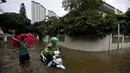 Pengendara motor melintasi banjir di Jalan Hang Lekir, Kebayoran Lama, Jakarta Selatan, Rabu (1/1/2020). Banjir tersebut disebabkan karena tingginya intensitas hujan yang mengguyur sejak Selasa (31/12/2019). (Liputan6.com/Johan Tallo)